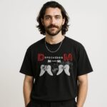 Mężczyzna w czarnym T-shircie Depeche Mode Wings Memento Mori z czerwonymi literami DM i białymi skrzydłami