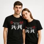 Mężczyzna i kobieta w czarnych T-shirtach Depeche Mode Wings Memento Mori z czerwonymi literami DM i białymi skrzydłami