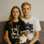 Para z kotem w T-shirt Nie Mogę Kot Na Mnie Leży – merch dla miłośników futrzaków, bawełniany z humorystyczną ilustracją, na wspólne chillowanie.