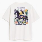 Tył białej koszulki z ilustracją jeźdźczyni wśród roślin