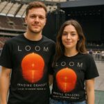 Para w T-shirtach Imagine Dragons Loom podczas koncertu na PGE Narodowym w Warszawie, edycja z grafiką zachodzącego słońca i datą 18–19.07.2025