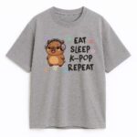 Szara koszulka z nadrukiem słodkiej kapibary w słuchawkach i napisem Eat Sleep K-pop Repeat – modna i wygodna.